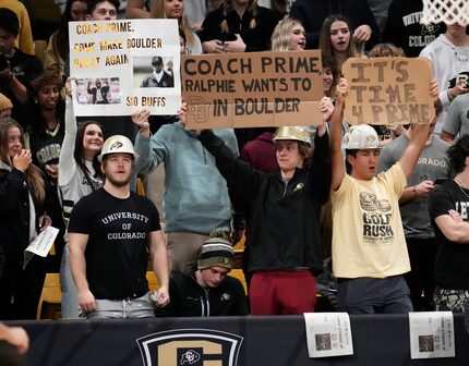 Fans hold up signs encouraging Jackson State head football coach Deion Sanders to take the...