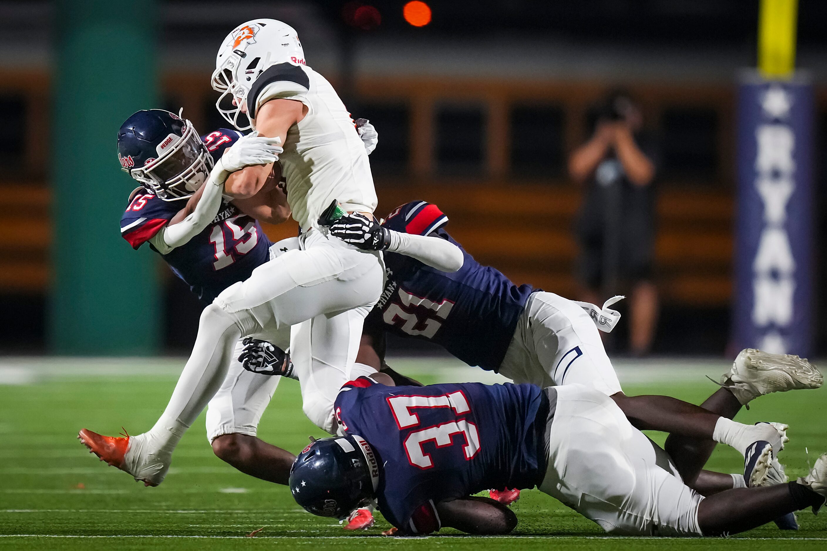 Aledo quarterback Hauss Hejny (8) is brought down by Denton Ryan defenders Trae Williams...