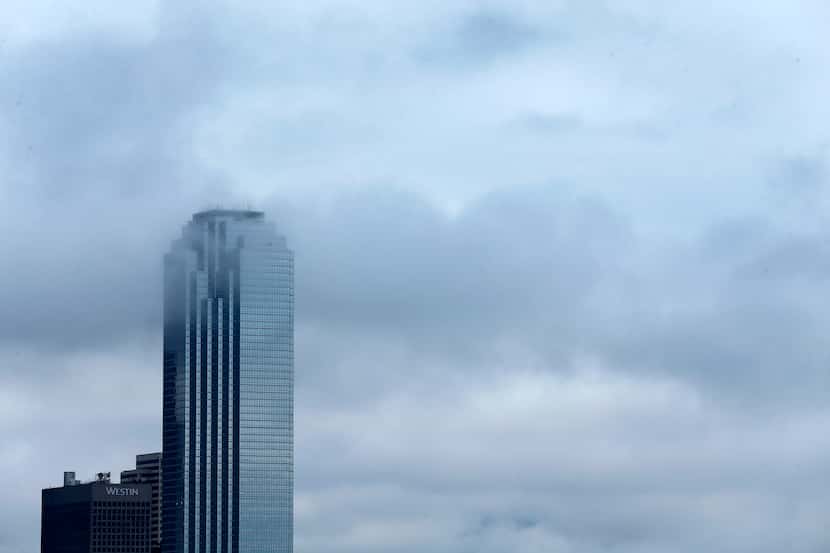 Lingering clouds drifted past the Bank of America building in downtown Dallas last weekend.