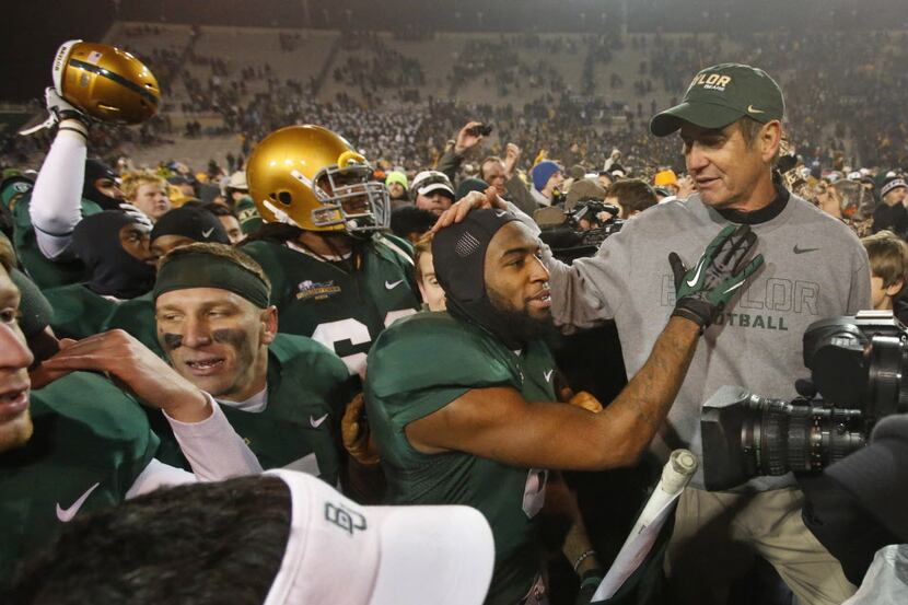 Baylor head coach Art Briles gets some love from safety Ahmad Dixon as they celebrate after...
