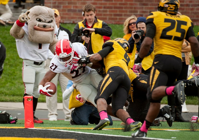 Georgia running back Nick Chubb, left, scores a touchdown as he gets past Missouri's Braylon...