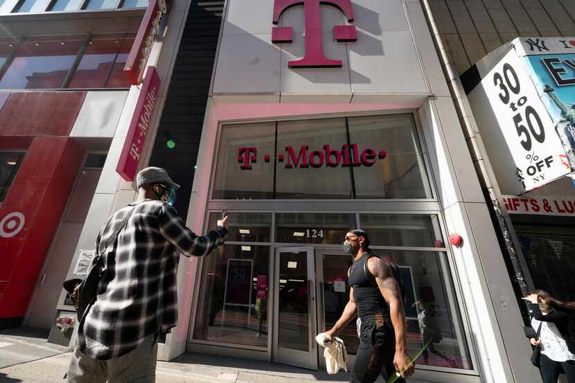 A man uses a mobile phone outside a T-Mobile store in April 2021 in New York.