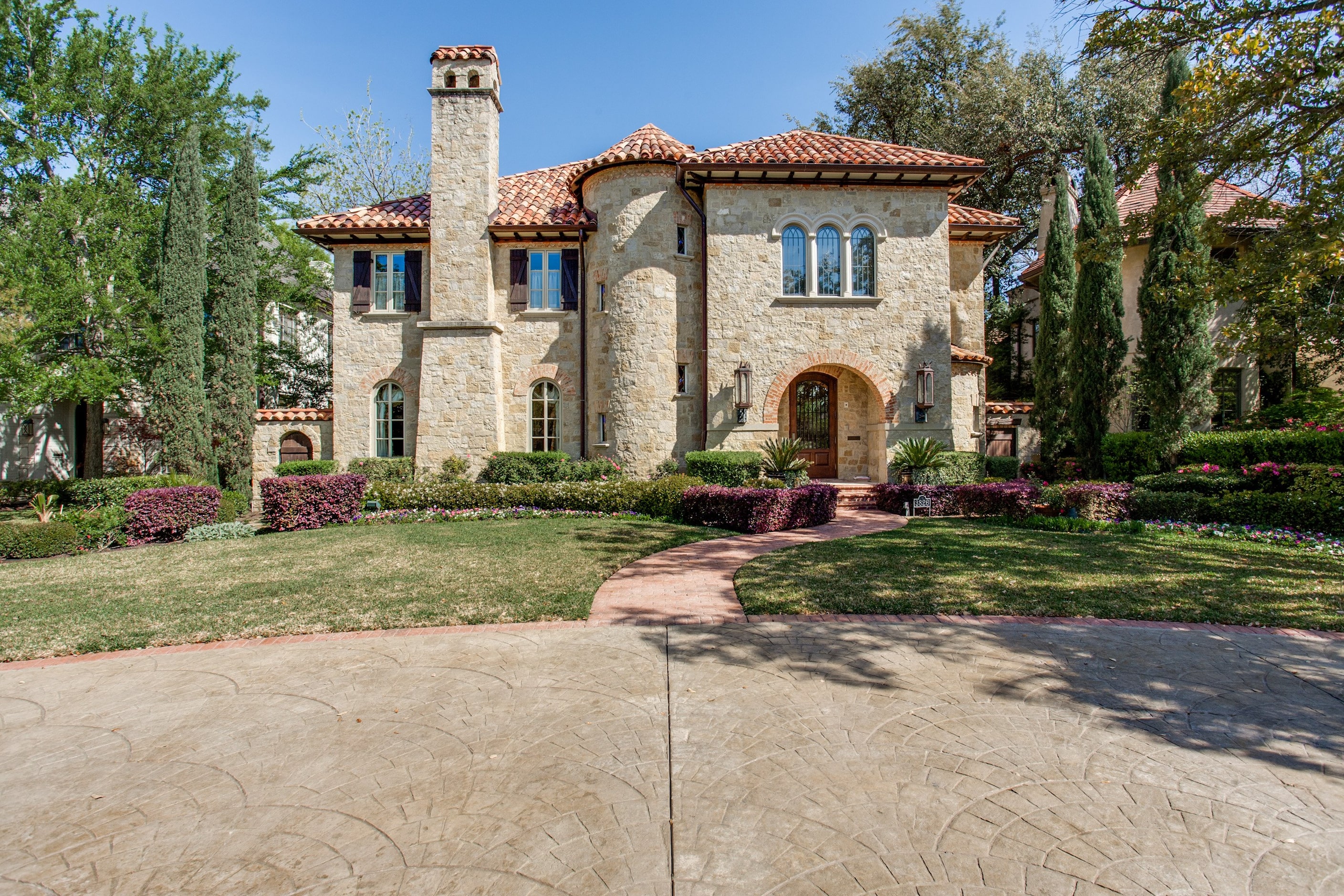 The home is anchored by arched double glass iron doors that open to formals with custom...