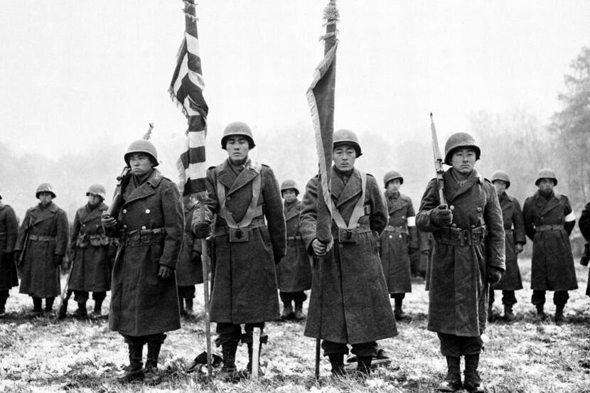Two color guards and color bearers of the Japanese-American 442nd Combat team stand at...