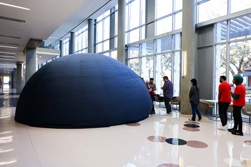 Teachers enter the traveling planetarium for a training session on the upcoming solar...