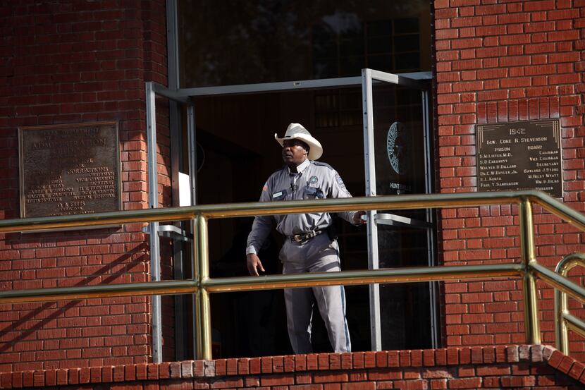 A Texas correction officer keeps watch outside the Texas Department of Criminal Justice...