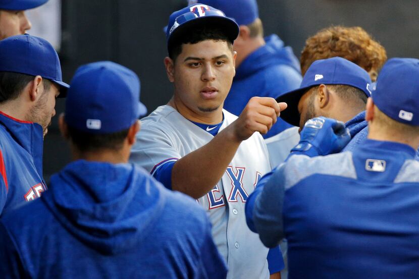 CHICAGO, IL - MAY 19: Ariel Jurado #57 of the Texas Rangers is congratulated in the dugout...