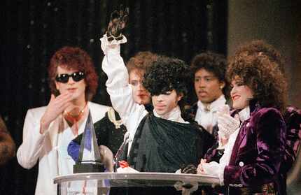 In this Jan. 28, 1985 file photo, pop vocalist Prince holds up a hand as he and his band The...