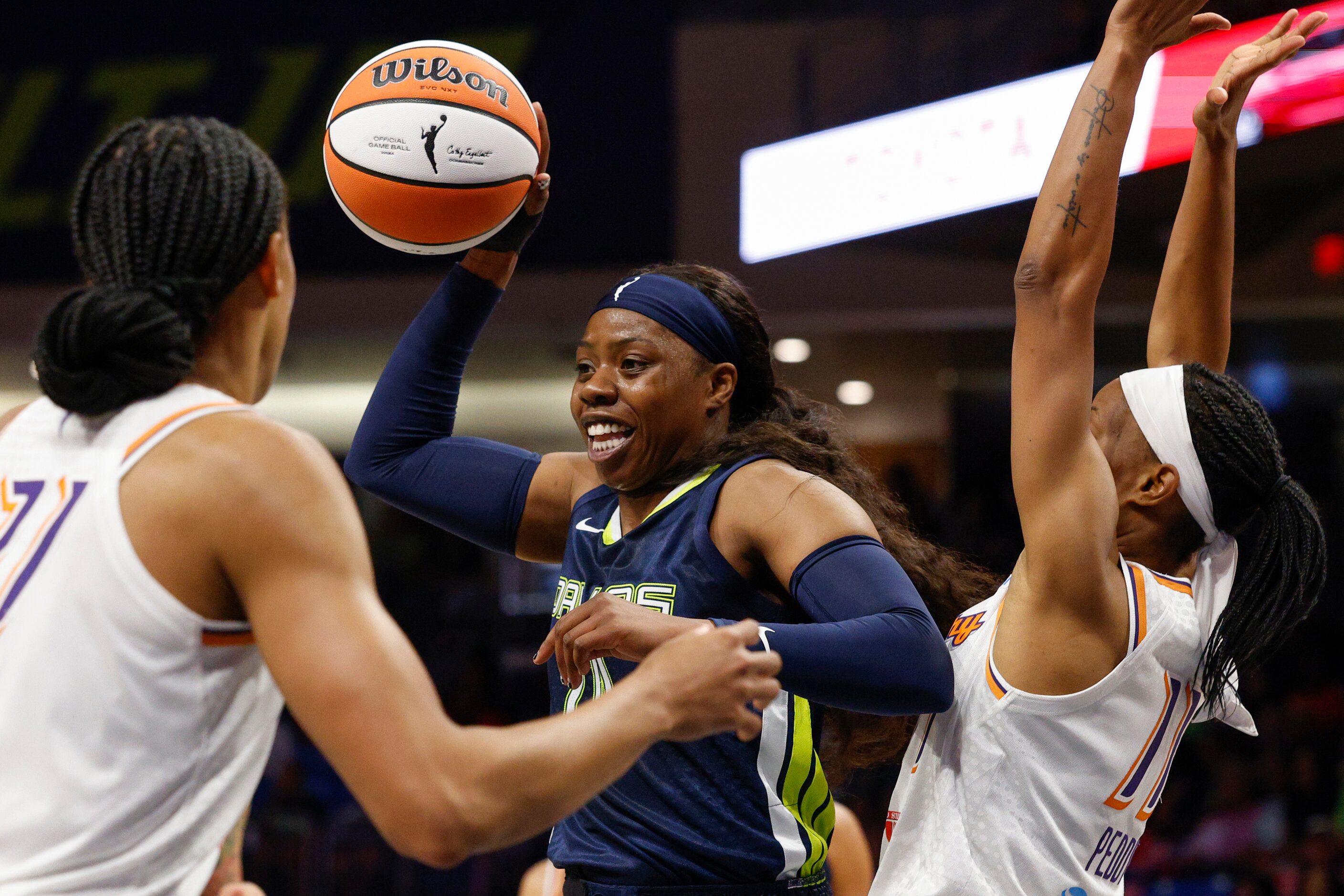 Dallas Wings guard Arike Ogunbowale (24) passes the ball between Phoenix Mercury forward...