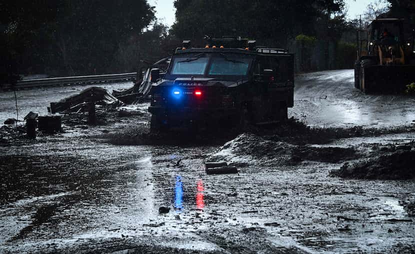 A police vehicle drives across a flooded side road off the US 101 freeway near the San...