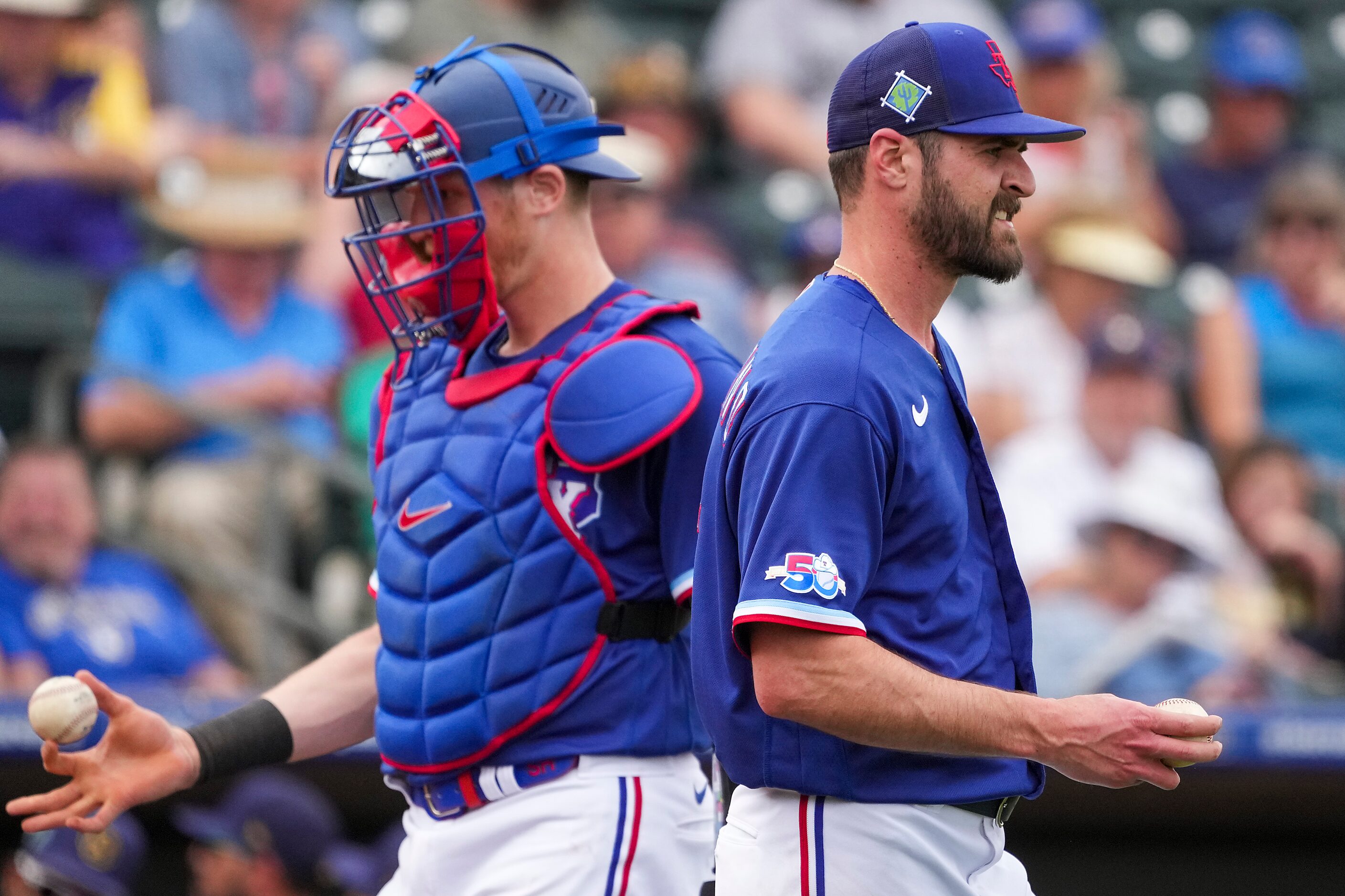 Texas Rangers pitcher Nick Tropeano gets a news ball as catcher Sam Huff prepares to toss...