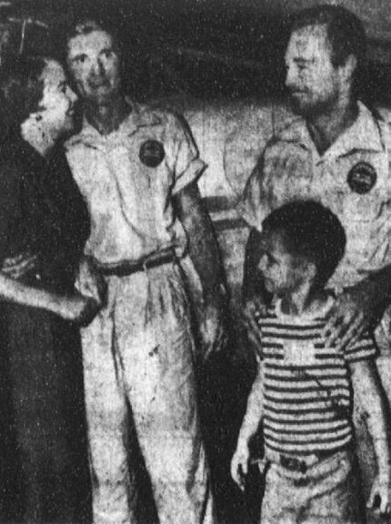 Jim Heth (left) and Bill Burkhart (right) are greeted by their families after they land,...