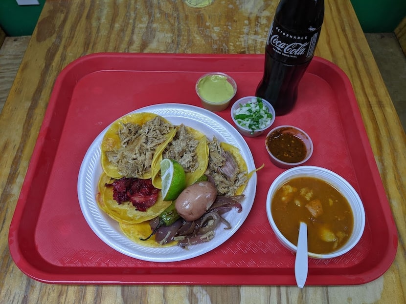 Un platillo de tacos en Carnitas La Cotorra con tacos de carnita y de trompo.