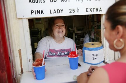 Owner Lee Albert serves Connie Garcia of Dallas as last year's snow-cone season got...