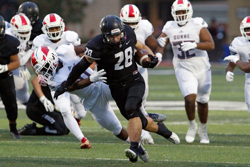 Bishop Lynch senior running back Jacob Lewis (28) runs for positive yardage before being...