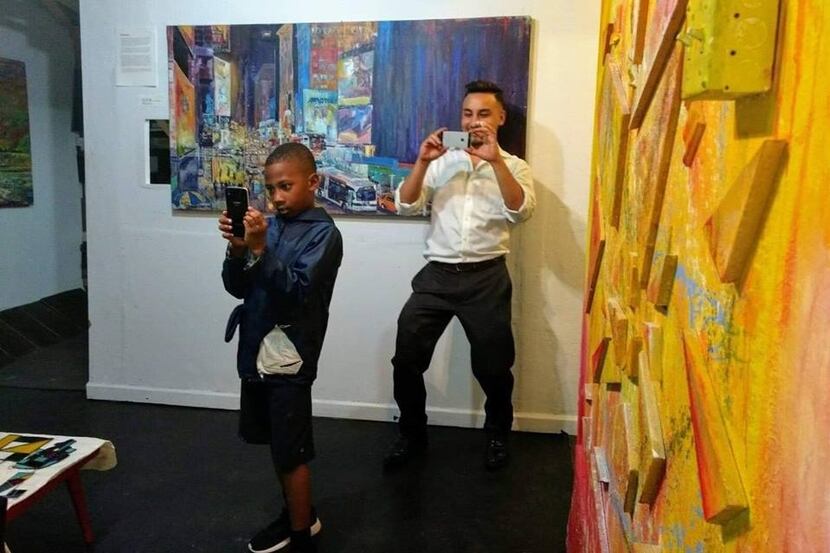 Artist Arjoon KC (right) snaps a photo in his AFactory Studio in Irving.