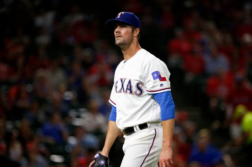 Texas Rangers starting pitcher Cole Hamels walks off the mound after the 7th inning against...