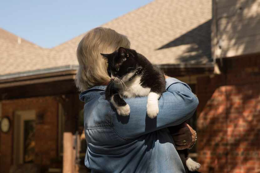 Sally Kilgore plays with her cat, Bob, who is known to prowl the garden.