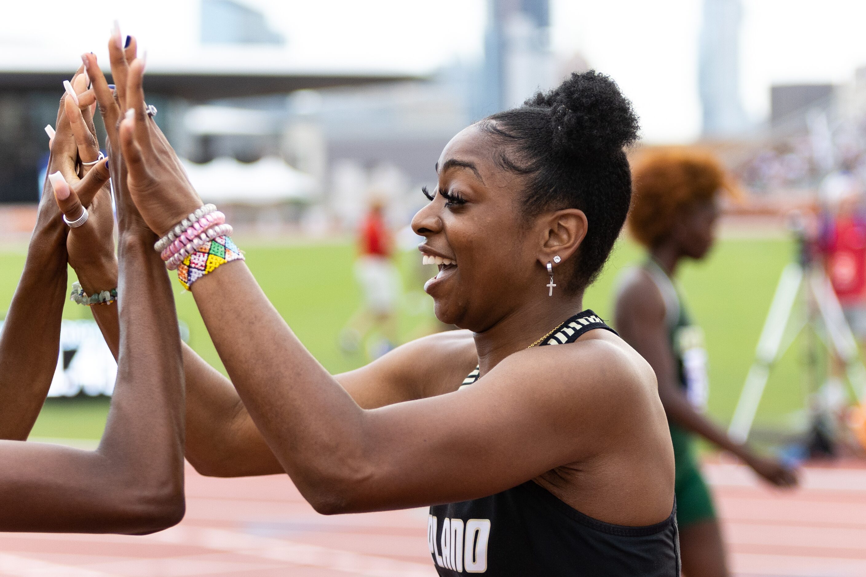 Tiriah Kelley of Plano East celebrates with a competitor after winning the girls' 100-meter...