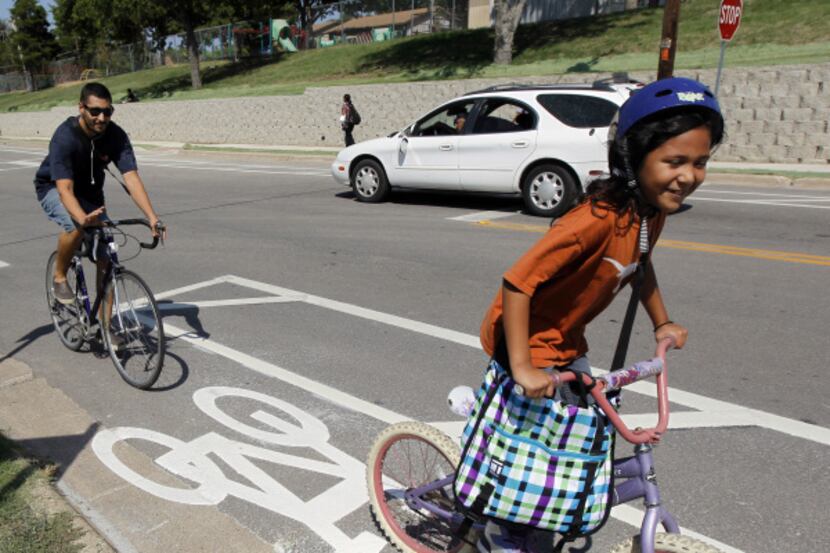 Valentin Rodriguez rides with his daughter Sophia, 7, in the city's first nonshared bike...