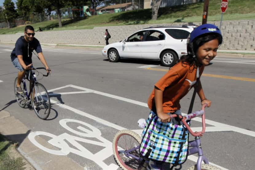 Valentin Rodriguez rides with his daughter Sophia, 7, in the city's first nonshared bike...