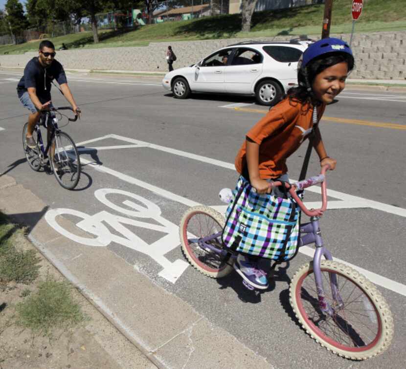 Valentin Rodriguez rides with his daughter Sophia, 7, in the city's first nonshared bike...