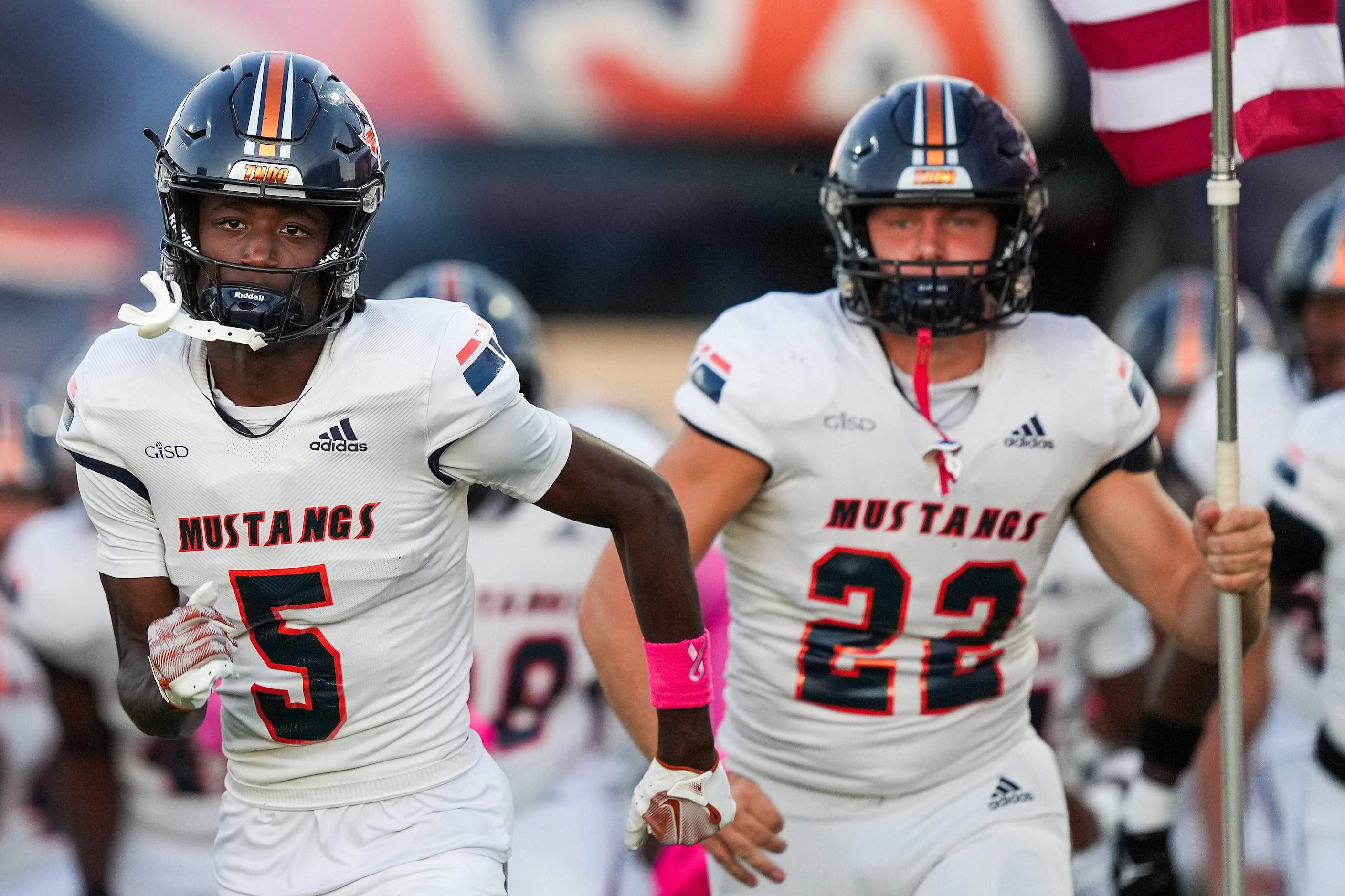 Sachse’s Kaliq Lockett (5) and Sean Davault (22) lead their team as they take the field...