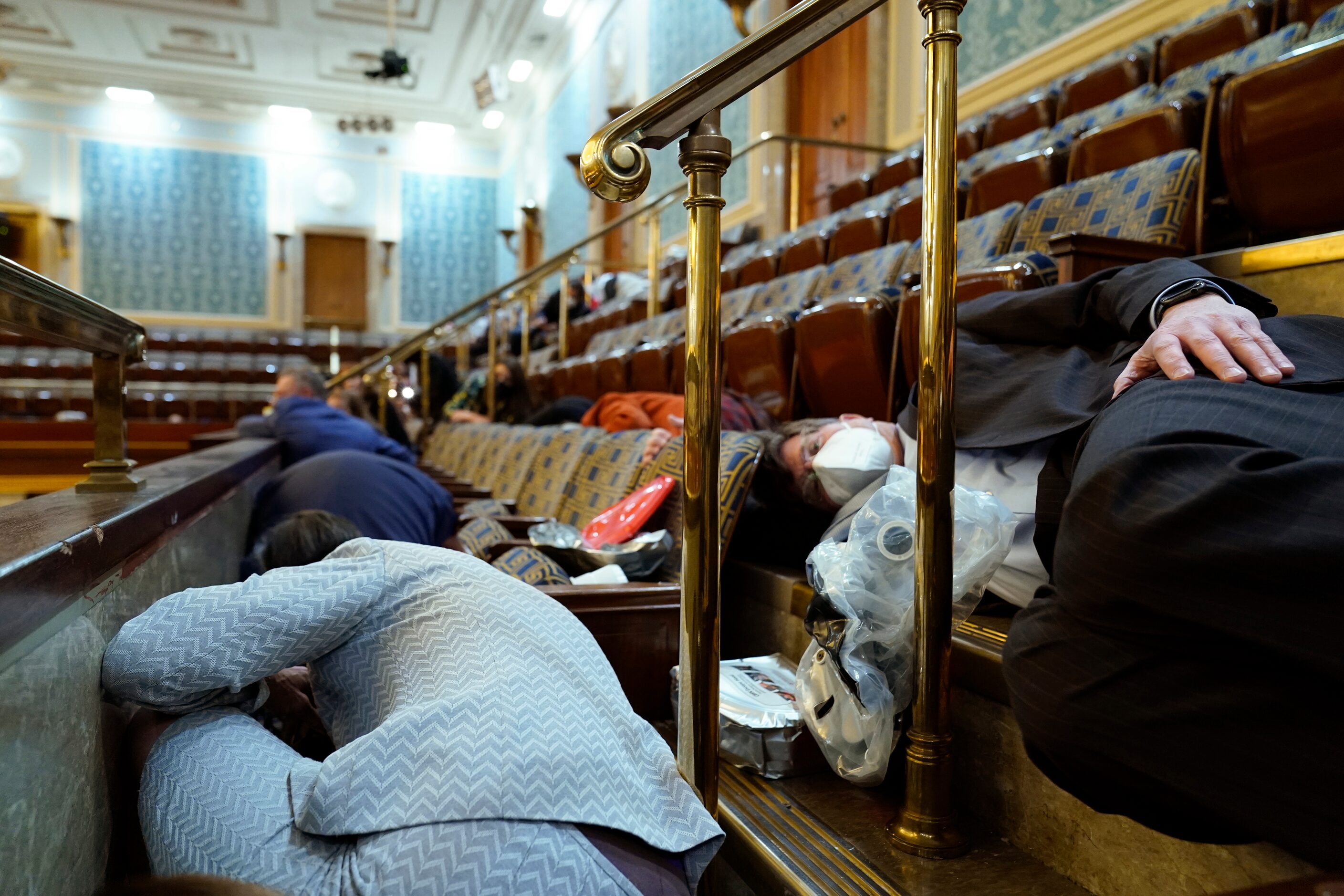 People shelter in the House gallery as protesters try to break into the House Chamber at the...