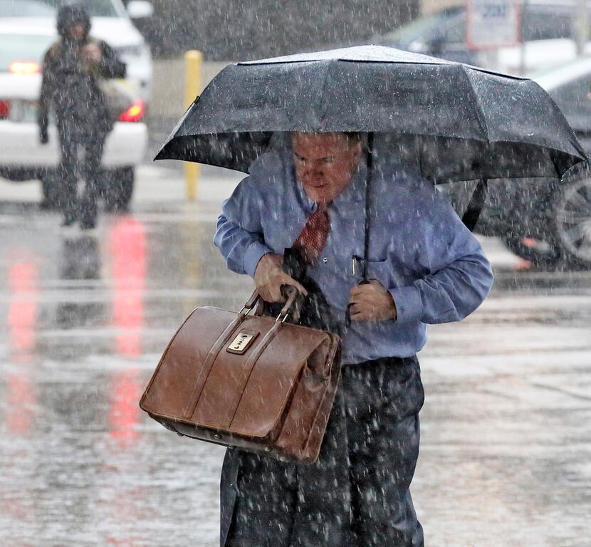 A man made his way through a downpour as he arrived at the Earle Cabell federal courthouse...