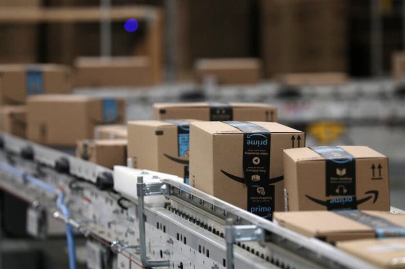 Packages pass down a conveyor belt before receiving a shipping label at Amazon in Shakopee,...