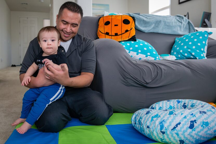 Robert Cano plays with his 10-month-old son, Brody, before leaving for work on a recent...