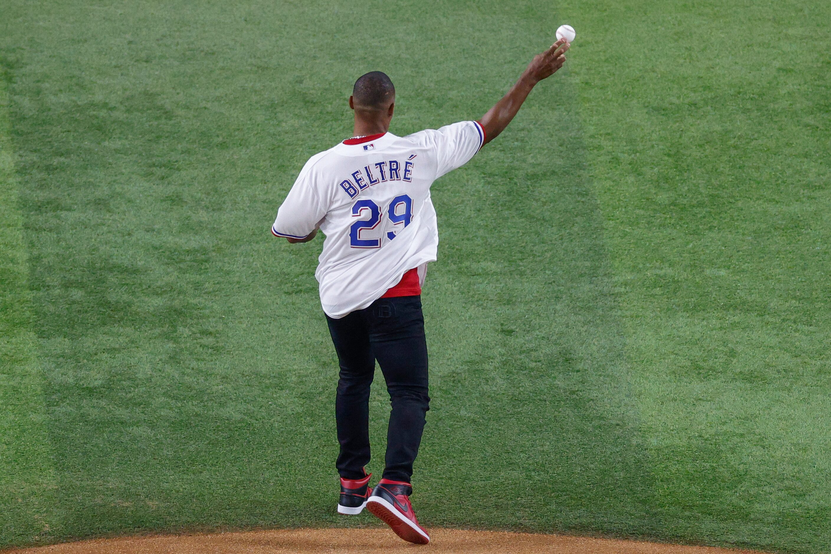 Former Texas Rangers third baseman Adrián Beltré throws the ceremonial pitch to former...