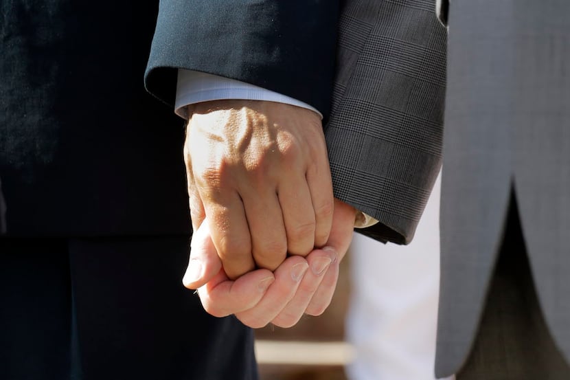 Texas marriage plaintiffs Vic Holmes, left, and partner Mark Phariss, right, hold hands on...