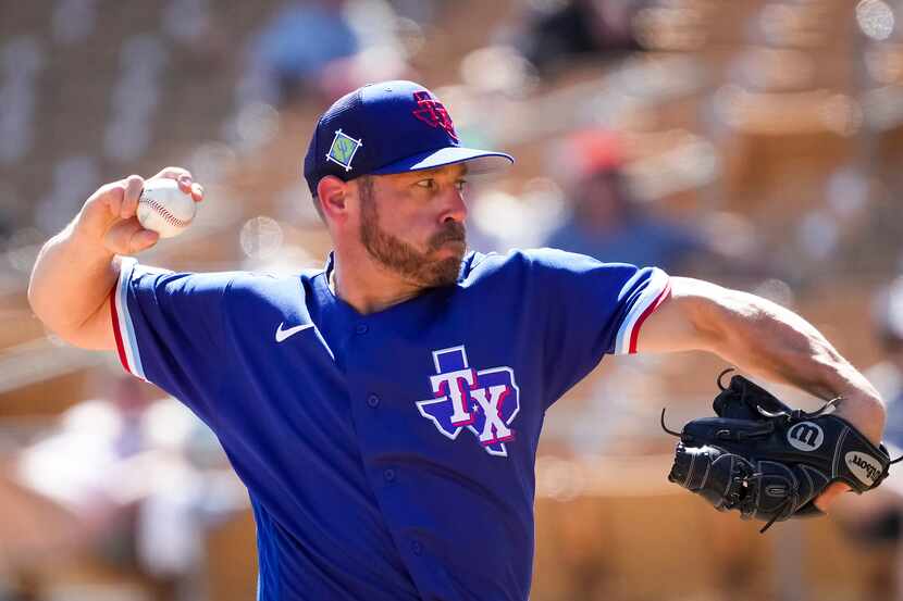Texas Rangers pitcher Greg Holland delivers during the fourth inning of a spring training...