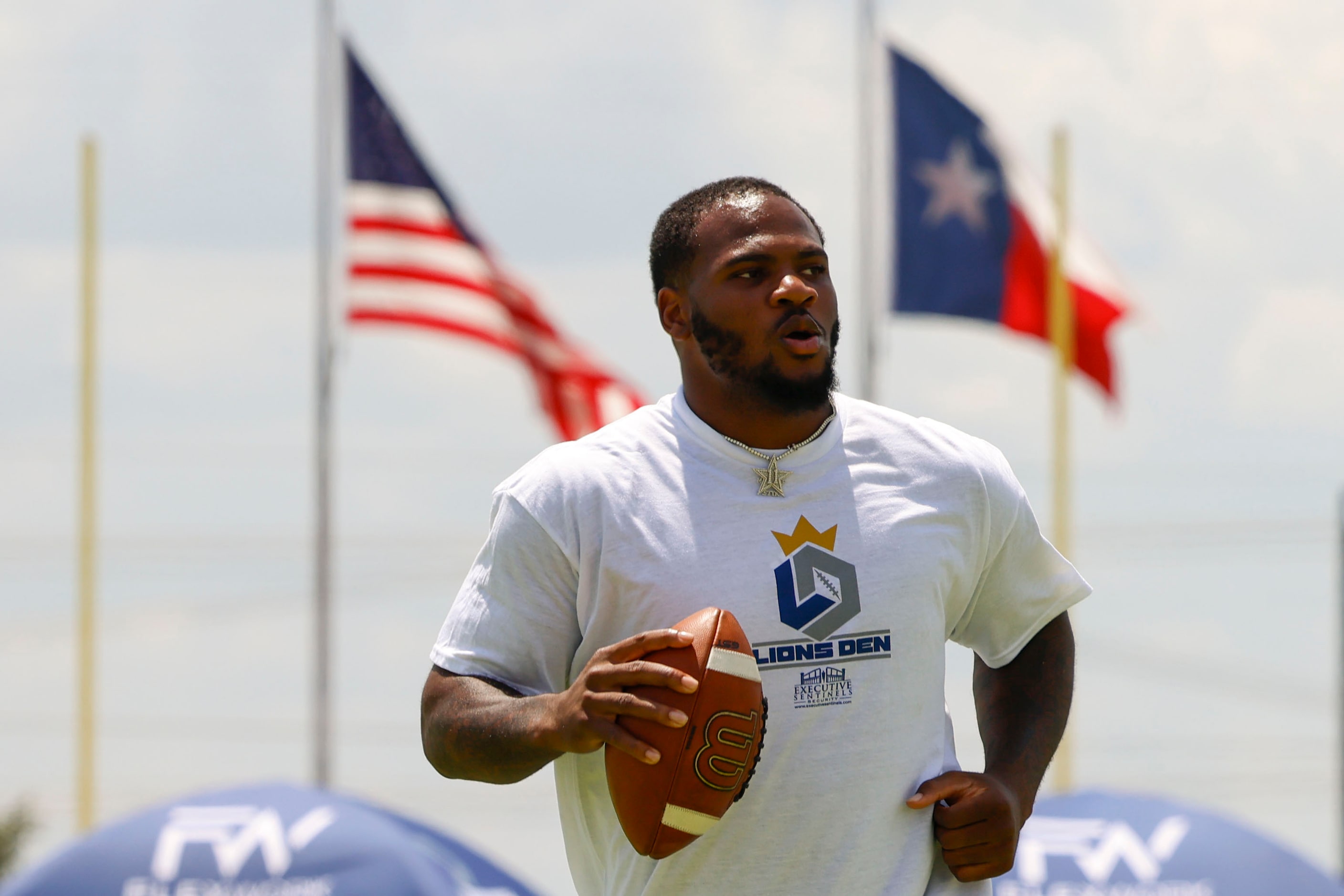 Dallas Cowboys linebacker Micah Parsons runs with the ball to at his youth football camp...