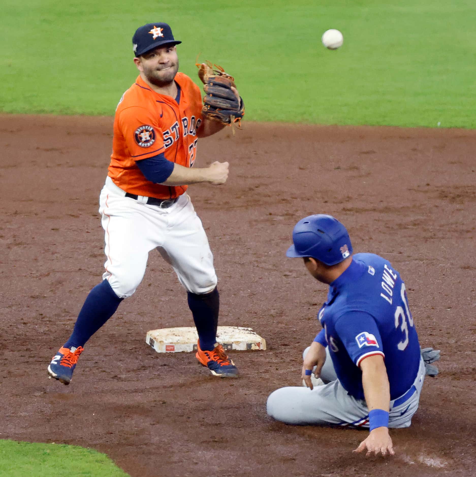 Houston Astros second baseman Jose Altuve (27) turns the front end of a double play to get...