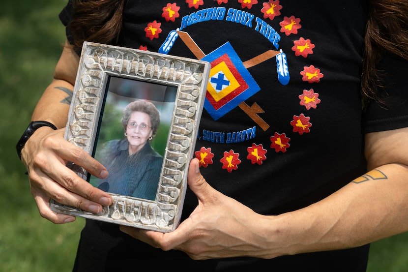 Stephen Silva Brave poses for a portrait with a photo of his grandmother, Eleanor Silva...