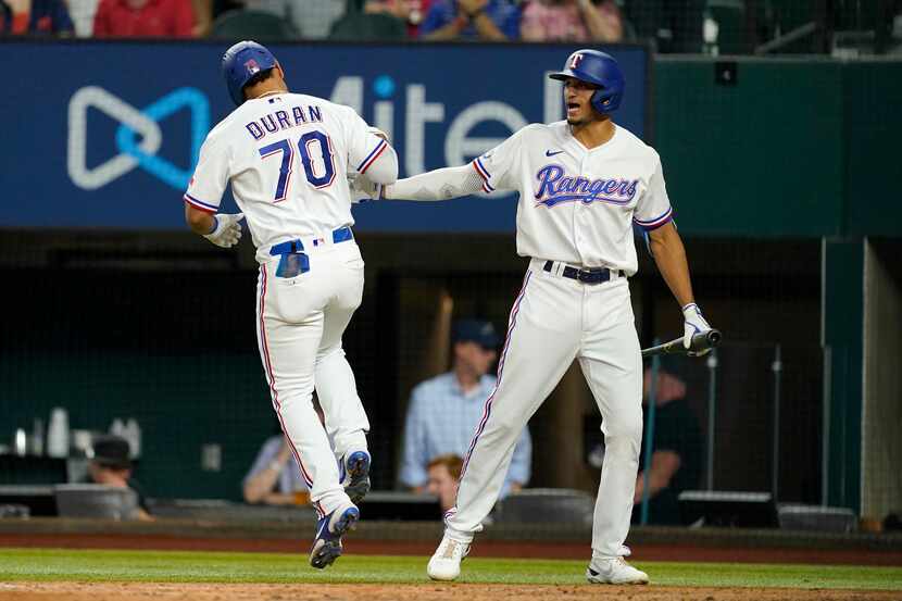 Texas Rangers' Ezequiel Duran (70) and Bubba Thompson celebrate Duran's solo home run...