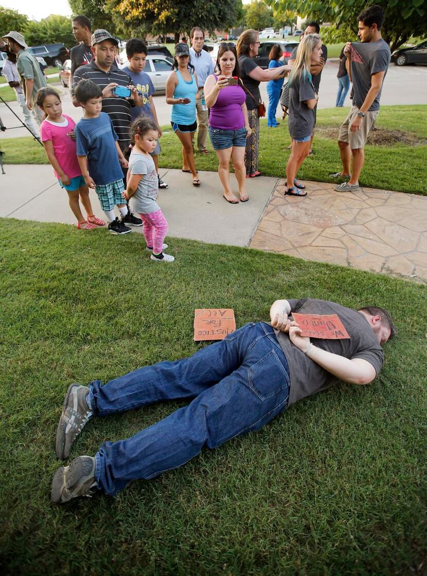 
A silent protester lay in the grass Monday in a pose similar to that of the girl who was...