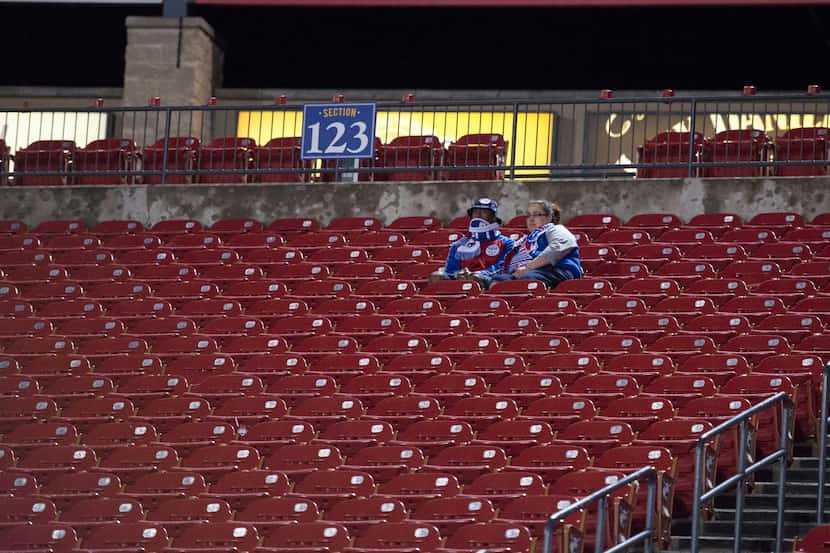 Apr 18, 2015; Dallas, TX, USA; A pair of FC Dallas fans wait for play to resume after a...