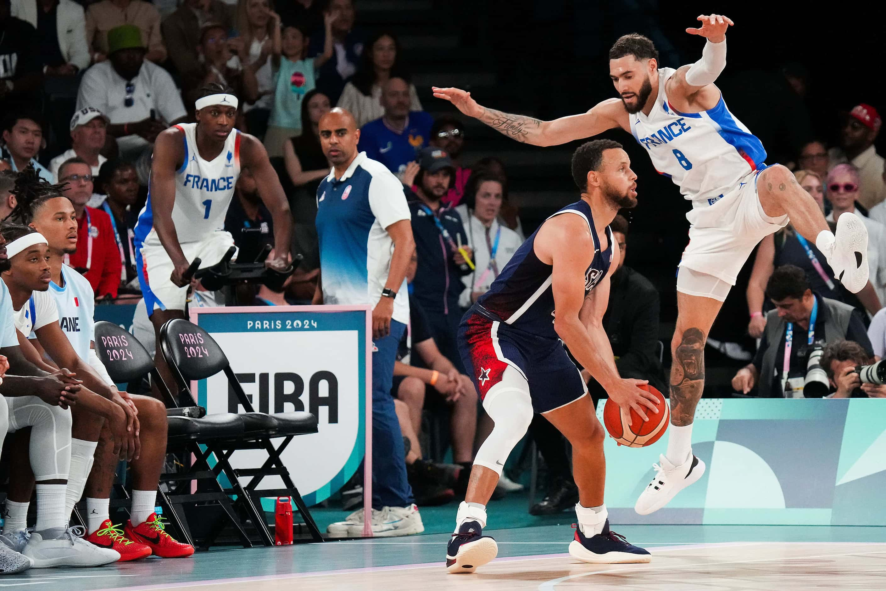 A pump fake by Stephen Curry (4) of the United States gets Isaia Cordinier (8) of France off...