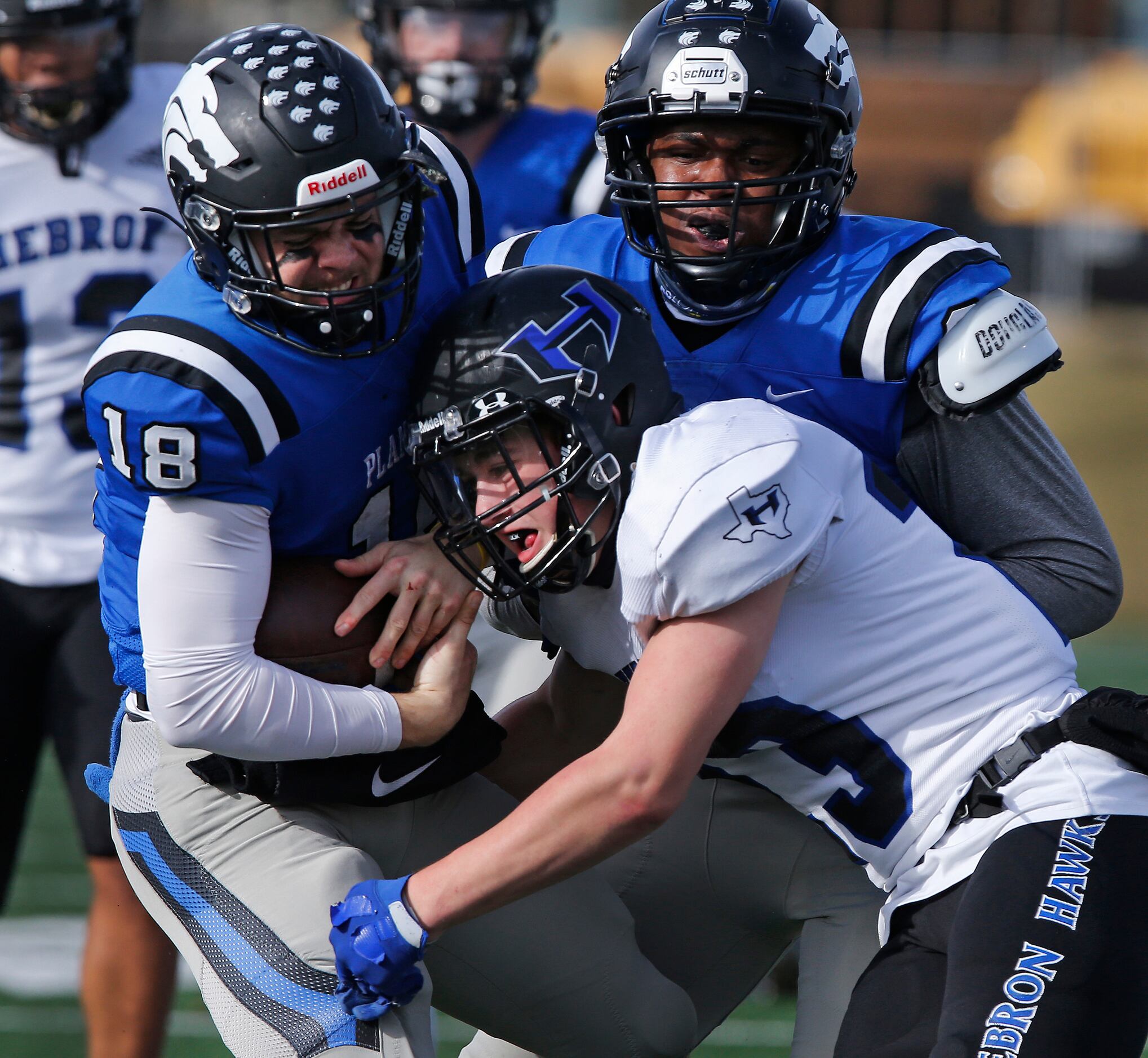 Plano West High School quarterback Greg Draughn (18) is tackled by Hebron High School safety...
