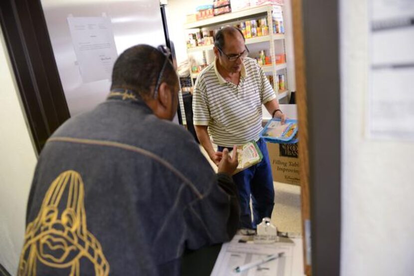 Volunteer Sammy Garza distributes food to Everett Joe Tatum at Lifenet. Lifenet also offers...