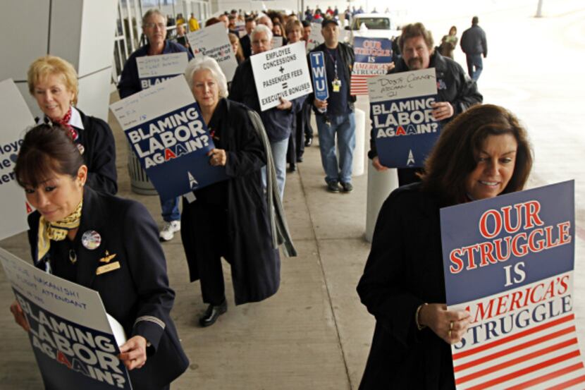 Employees representing unions of American Airlines picketed planned job cuts outside...