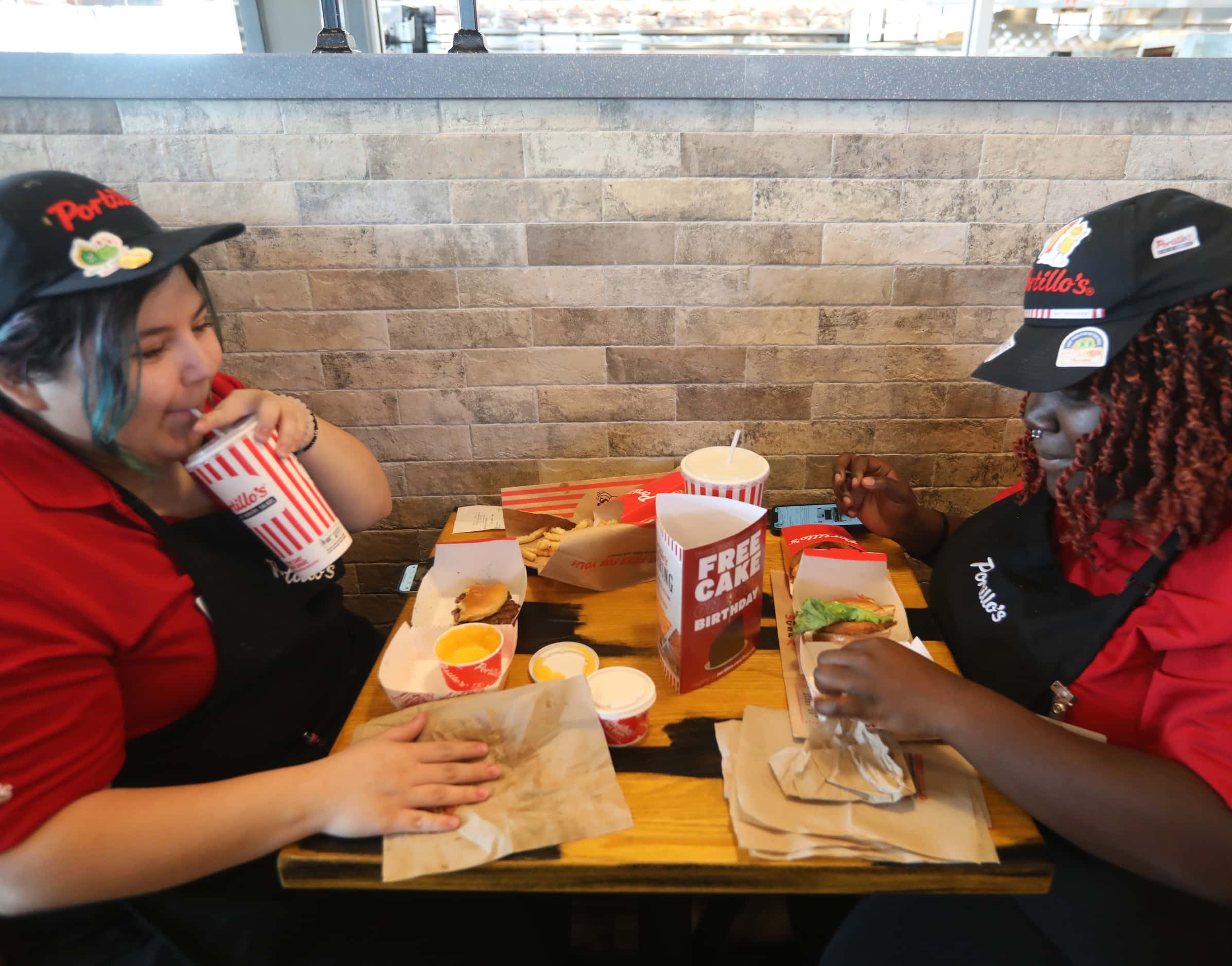 Whitney Ocampo, left, and Heidi Mensah enjoy a quick meal before the store opens at...