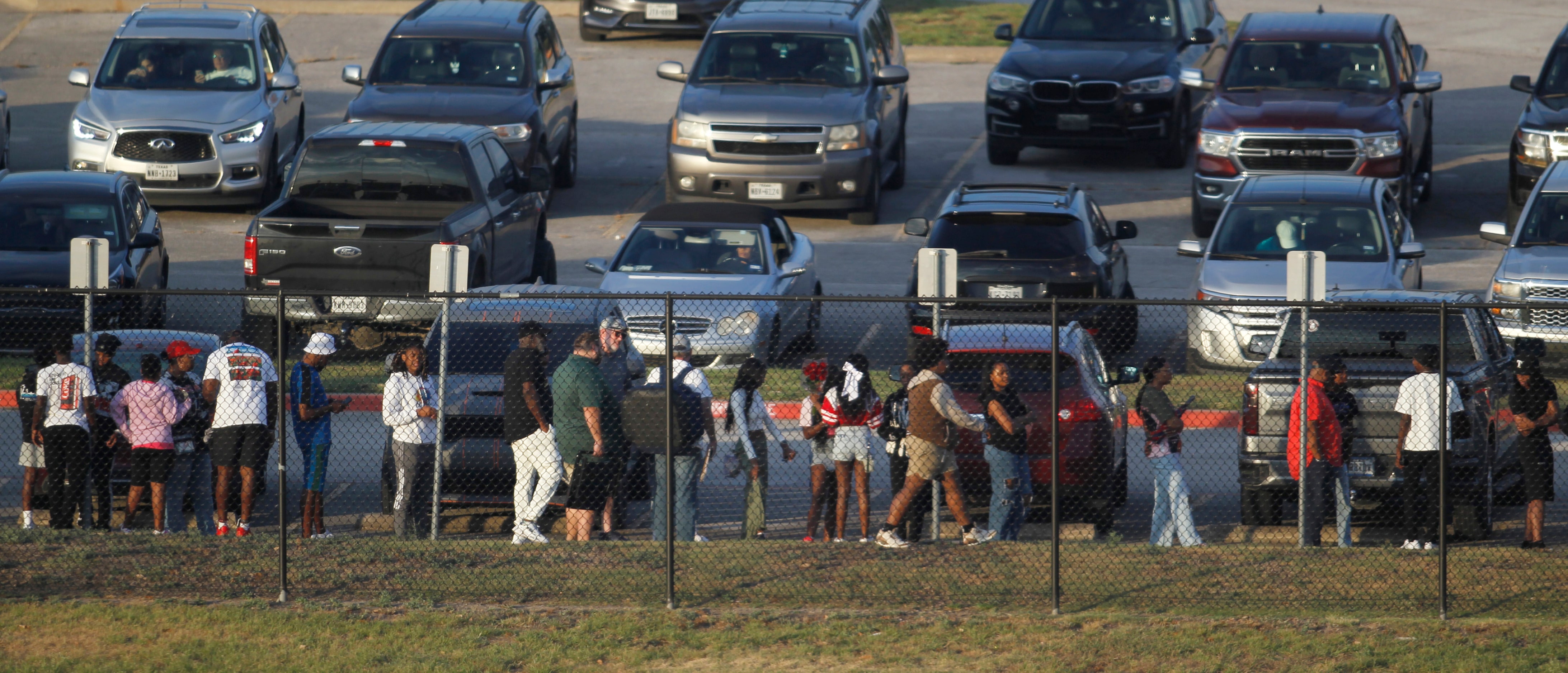 Duncanville fans form a long line outside the stadium during a lighting delay before the...