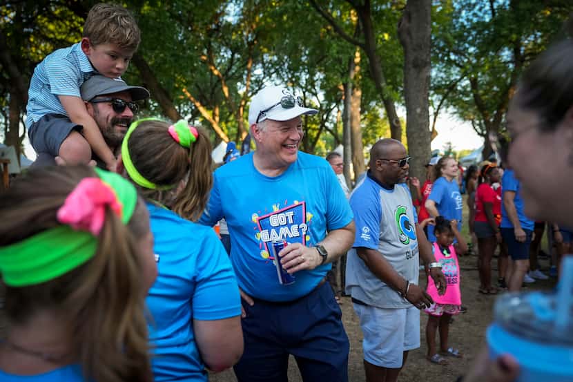Hill & Wilkinson CEO Paul Driscoll (center) laughs with employees at opening ceremonies for...