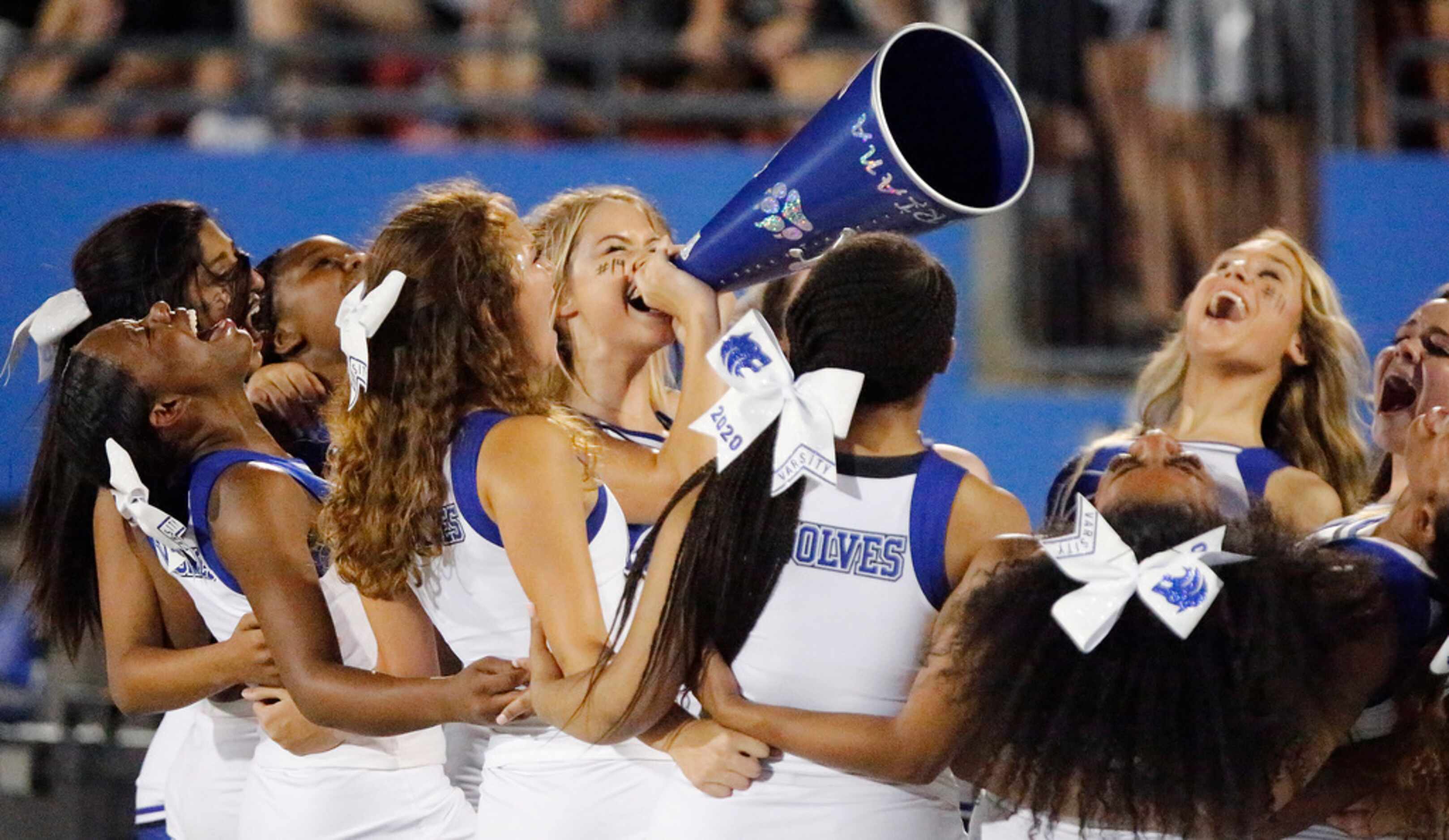 Plano West cheerleader echo Beth McCurry (center), 17, on the megaphone during the second...