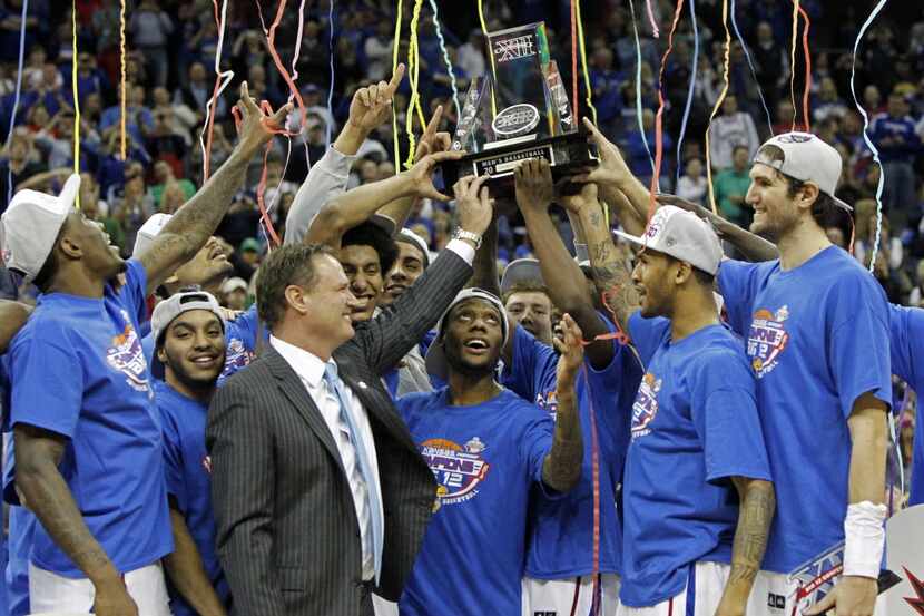 Member of the Kansas team celebrate with coach Bill Self after they defeated Kansas State...