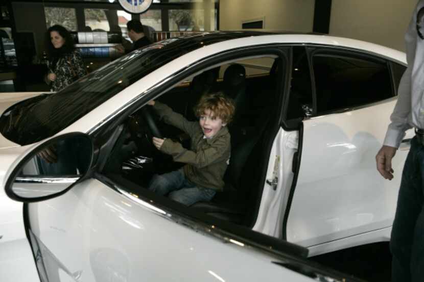 Walker Stephenson, 4, tries out the drivers seat of the new Fisker Karma ES. Walker was...